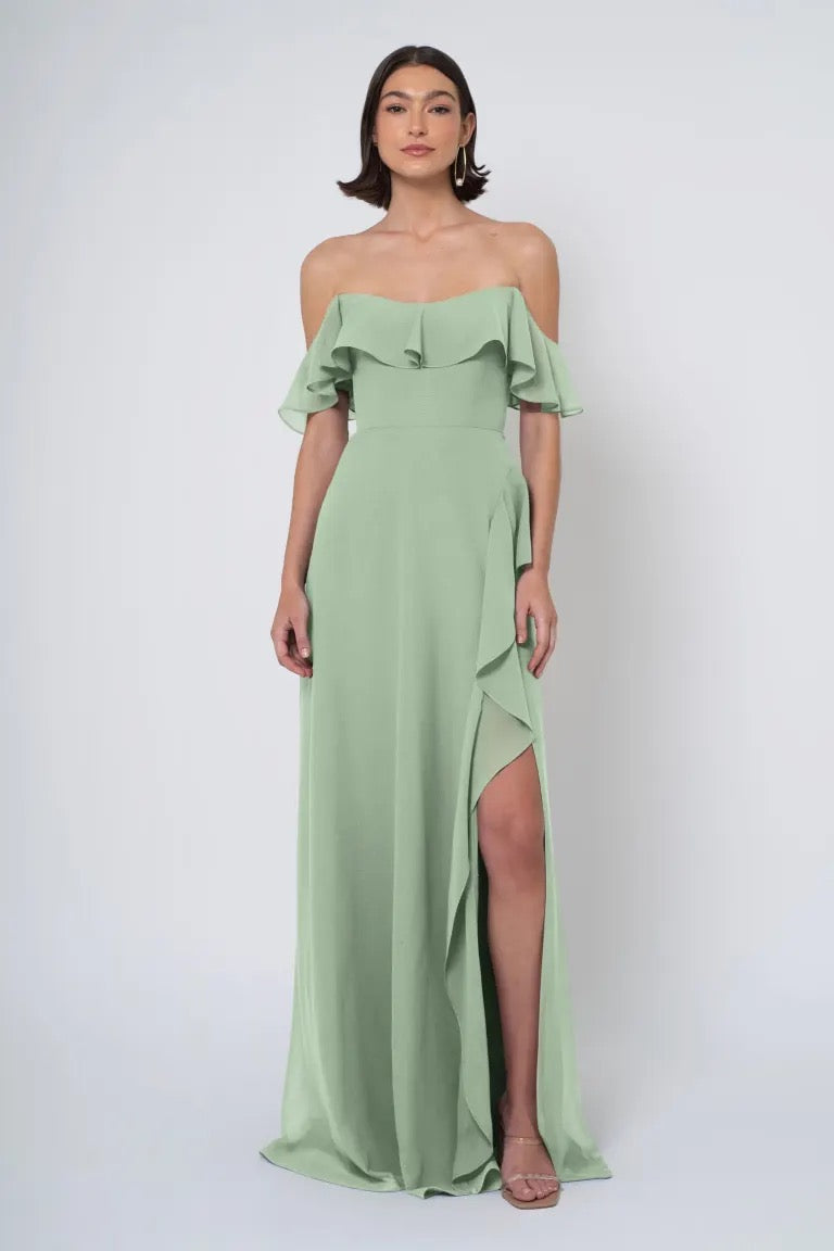 Woman in an elegant Jenny Yoo Bridesmaid Dress with a ruffled neckline and a high side slit, from Bergamot Bridal.