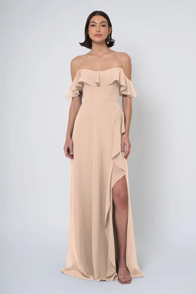 Woman in a Salma - Jenny Yoo Bridesmaid Dress with an off-the-shoulder neckline and a side slit from Bergamot Bridal.