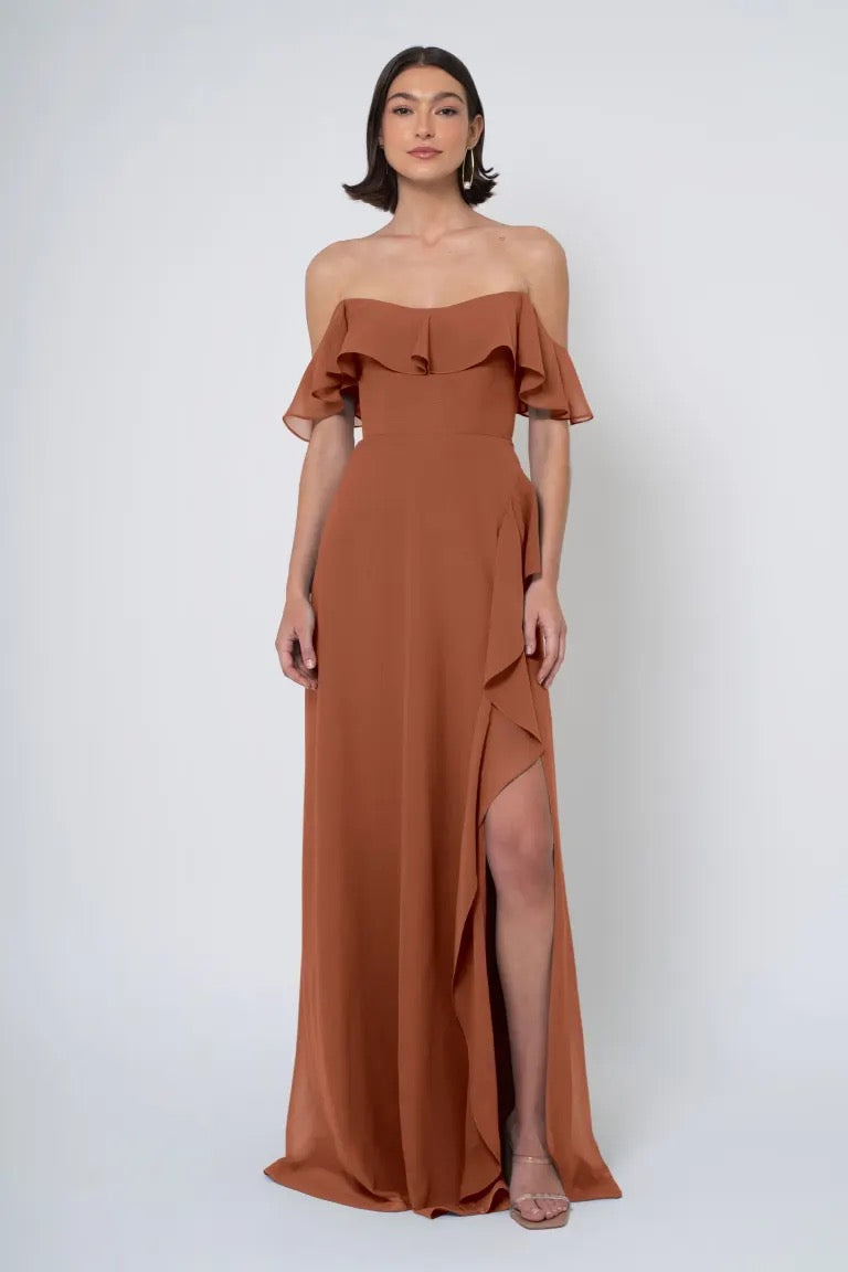 Woman in an elegant brown Jenny Yoo Bridesmaid Dress with a thigh-high side slit from Bergamot Bridal.