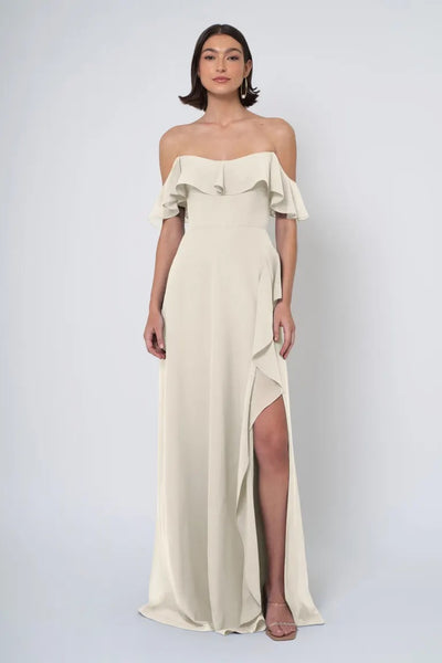 Woman in an elegant off-the-shoulder Jenny Yoo Bridesmaid Dress with a side slit from Bergamot Bridal.