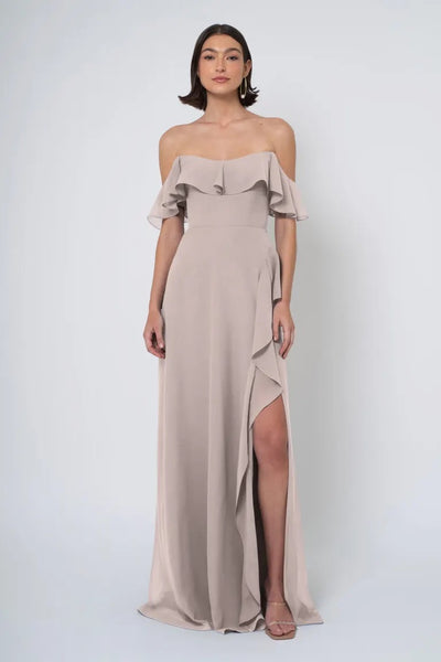 Woman posing in an elegant, Salma - Jenny Yoo Bridesmaid Dress with an off the shoulder neckline and side slit from Bergamot Bridal.