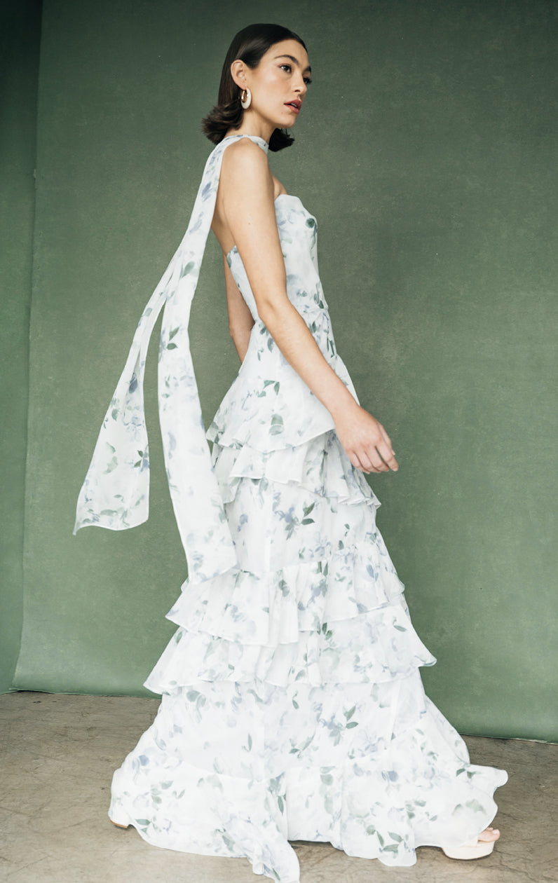 Woman in an elegant strapless cowl neckline Simona Print - Jenny Yoo Bridesmaid Dress with a ruffled skirt, posing against a plain backdrop from Bergamot Bridal.