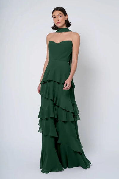 Woman posing in an elegant Jenny Yoo Bridesmaid Dress with a strapless cowl neckline and tiered ruffles from Bergamot Bridal.