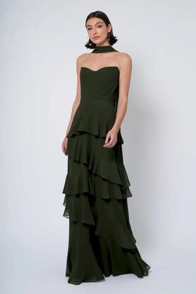 A woman in an elegant Jenny Yoo Bridesmaid Dress with a strapless cowl neckline and tiered ruffles from Bergamot Bridal.