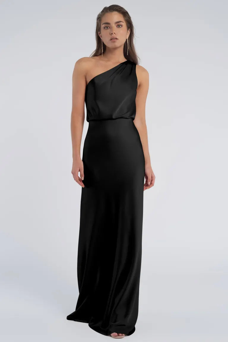 Woman posing in an elegant, old Hollywood-inspired black one-shoulder Sterling - Jenny Yoo Bridesmaid dress from Bergamot Bridal.