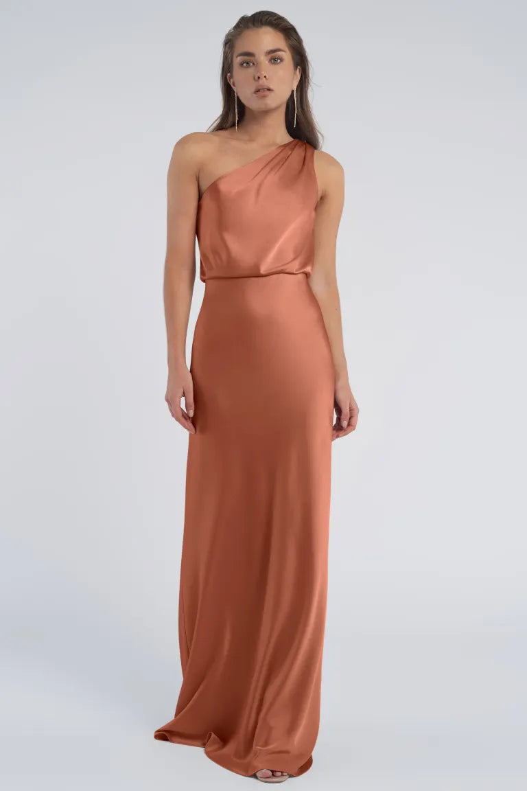 A woman in a Sterling - Jenny Yoo Bridesmaid evening gown with a one-shoulder neckline posing against a plain background.