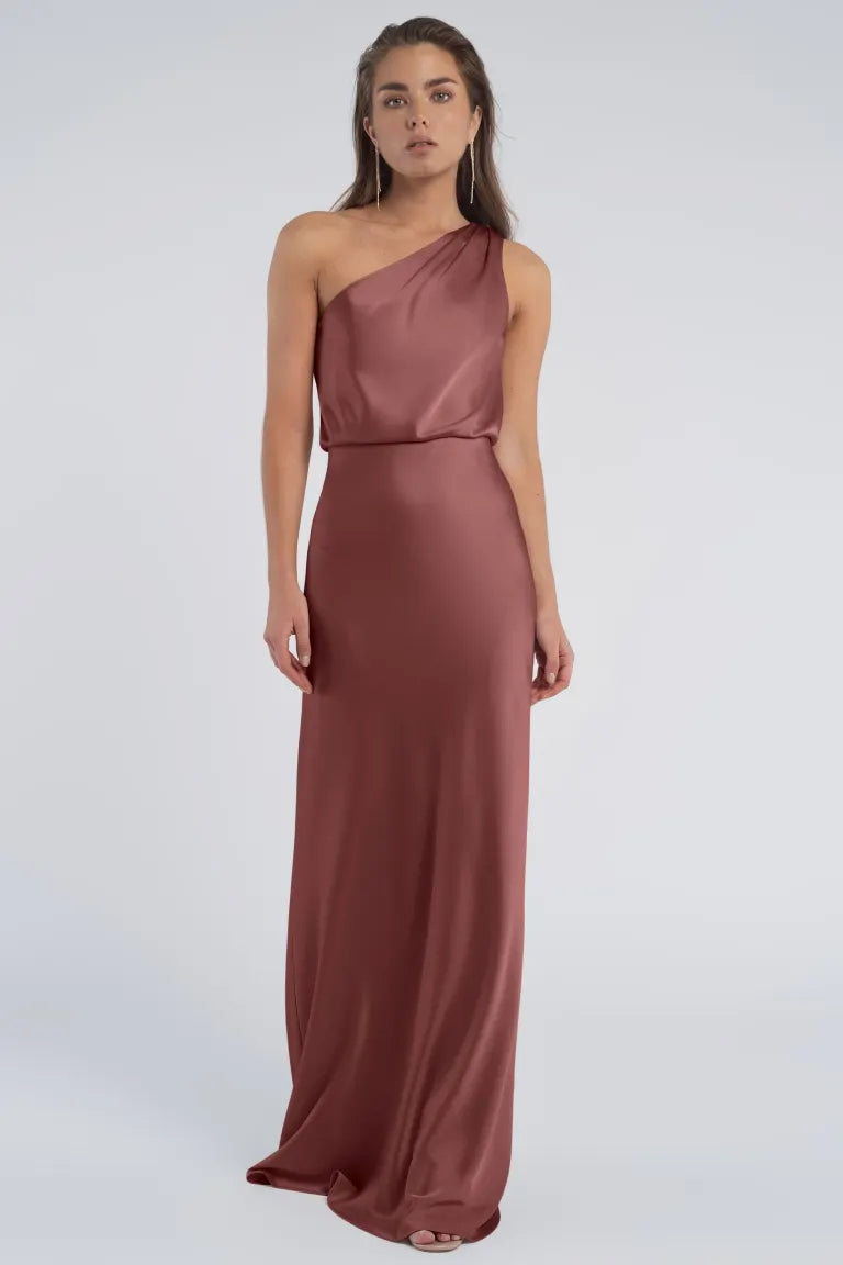 Woman in an elegant, one-shoulder neckline burgundy evening gown by Sterling - Jenny Yoo Bridesmaid from Bergamot Bridal.