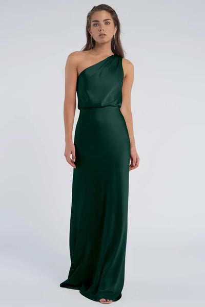 Woman in an elegant Jenny Yoo Bridesmaid dress with a one-shoulder neckline, crafted from luxe satin fabric, standing against a neutral background.