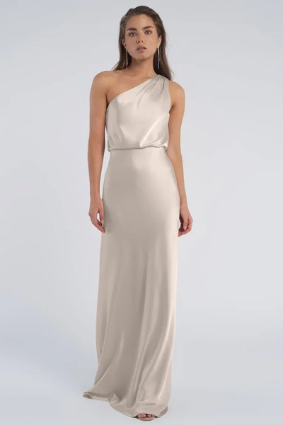 Woman in an elegant one-shoulder neckline cream gown crafted from luxe satin fabric against a neutral background, known as the Sterling - Jenny Yoo Bridesmaid dress from Bergamot Bridal.