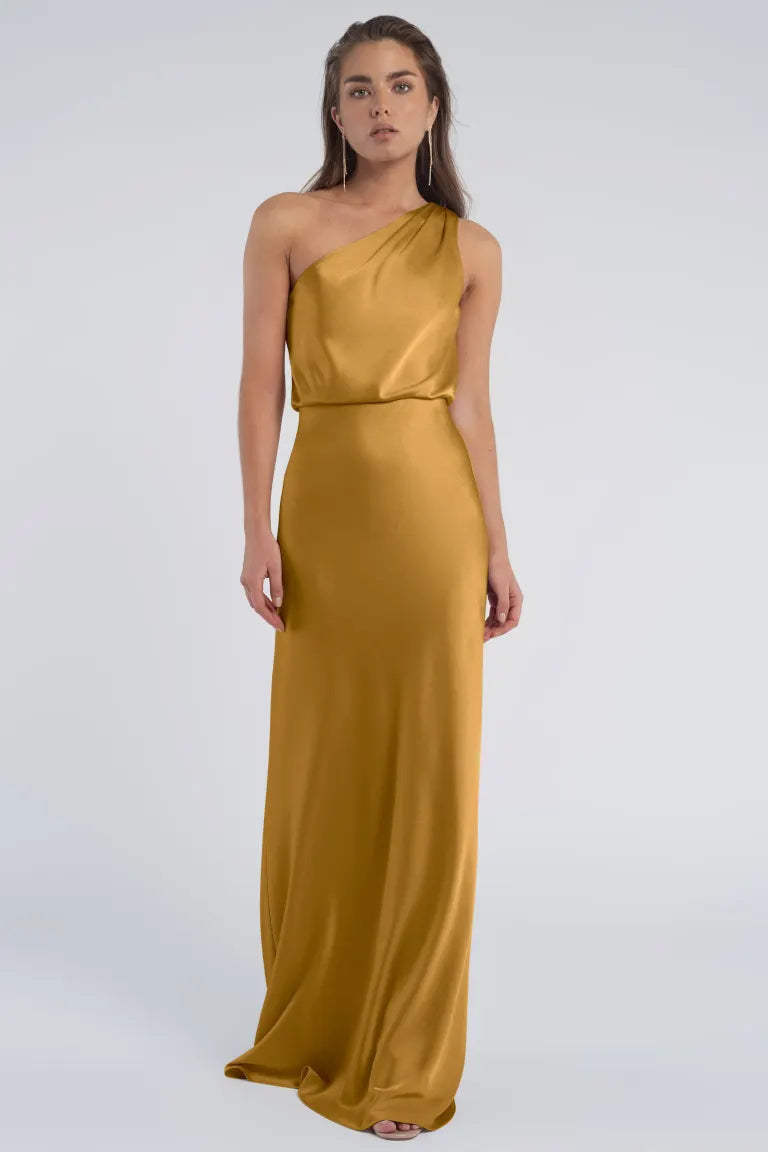 Woman wearing a golden Sterling - Jenny Yoo Bridesmaid evening gown with a luxe satin fabric from Bergamot Bridal.