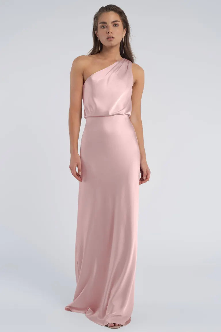 Woman posing in a pink Sterling - Jenny Yoo Bridesmaid dress with a one-shoulder neckline from Bergamot Bridal.