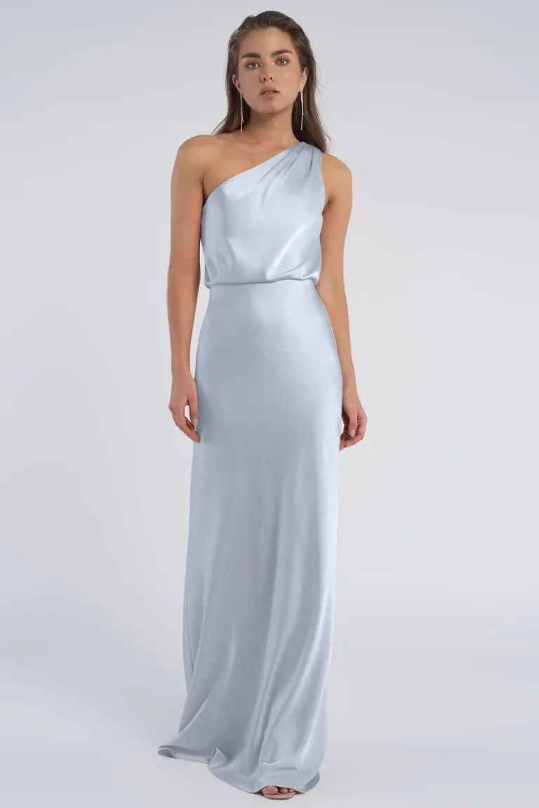 Woman in a light blue Sterling - Jenny Yoo Bridesmaid luxe satin fabric one-shoulder evening gown from Bergamot Bridal.