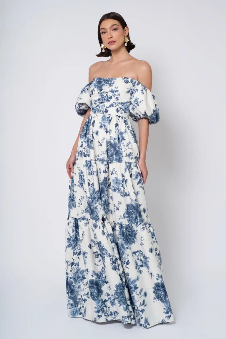 A woman models an off-the-shoulder blue and white floral Jenny Yoo Bridesmaid Dress with detachable puff sleeves from Bergamot Bridal.