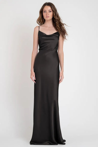 A woman wearing a long black Sylvie - Bridesmaid Dress by Jenny Yoo slip dress from Bergamot Bridal.