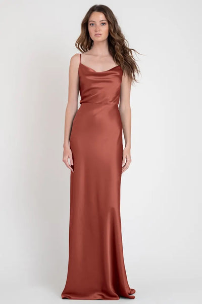 Model showcasing a long, rust-colored Sylvie - Bridesmaid Dress by Jenny Yoo evening gown from Bergamot Bridal.