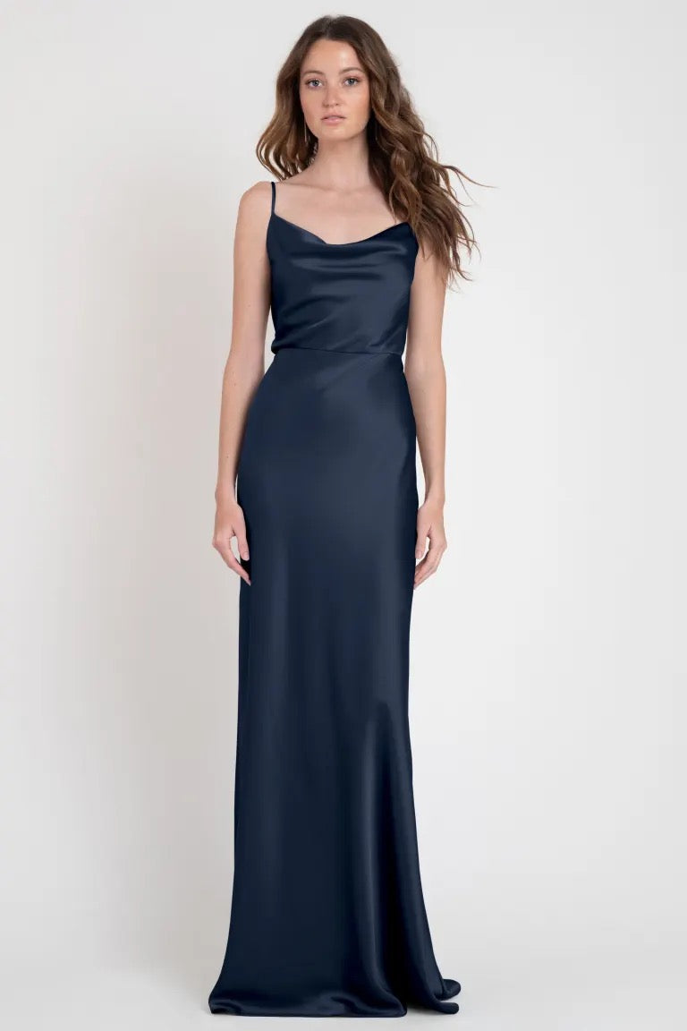 A woman modeling a stylish sleeveless navy blue Sylvie Bridesmaid Dress by Jenny Yoo from Bergamot Bridal.