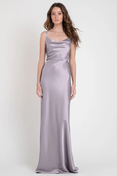 Woman in a long Hollywood satin silver slip dress standing against a neutral background, showcasing the show-stopping Sylvie - Bridesmaid Dress by Jenny Yoo from Bergamot Bridal.