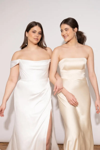 Two women in elegant Jenny Yoo Wedding Dresses from Bergamot Bridal, off-the-shoulder, smiling and posing together.