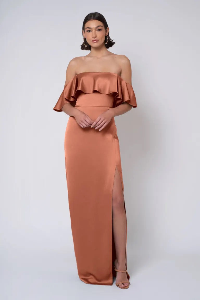 Woman in an elegant strapless neckline, column skirt copper gown with a thigh-high slit - Winter by Jenny Yoo Bridesmaid Dress from Bergamot Bridal.