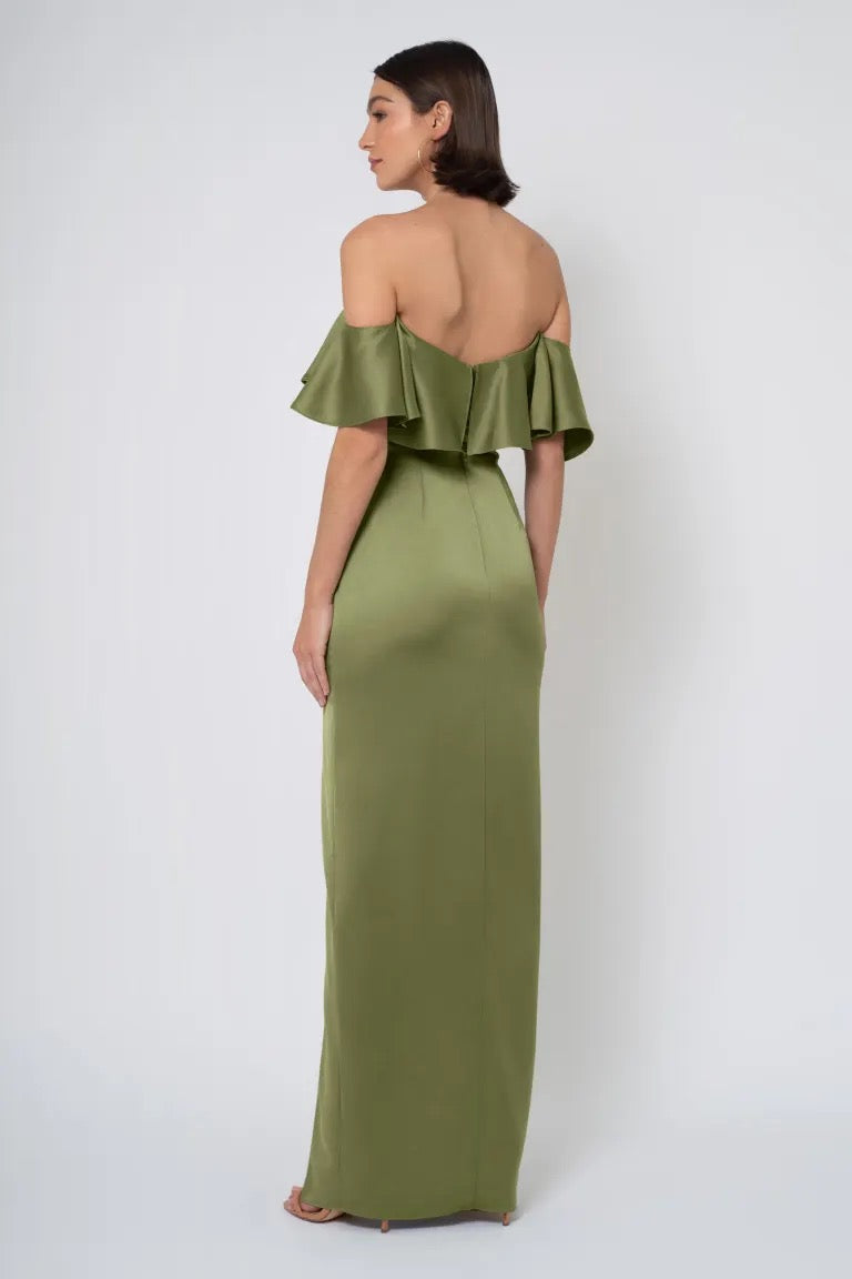 A woman wearing an olive green strapless off-the-shoulder ruffle gown, Winter by Jenny Yoo Bridesmaid Dress by Bergamot Bridal, viewed from behind.