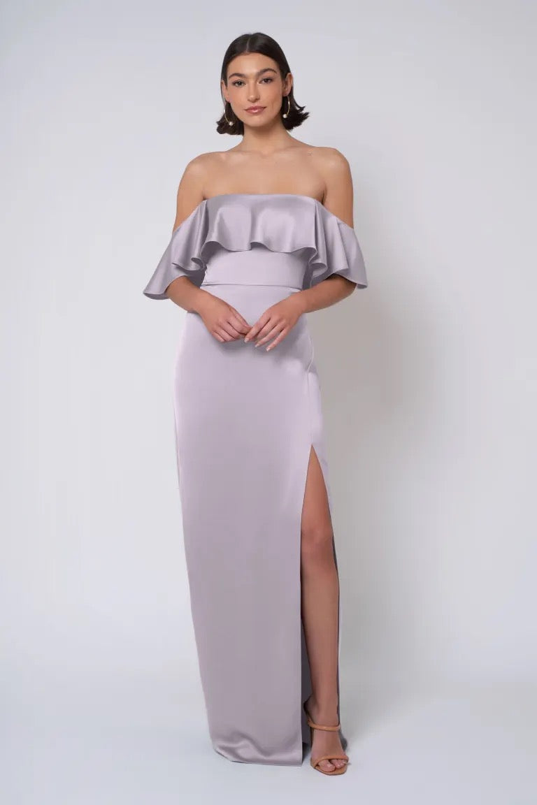 Woman wearing an elegant strapless, light purple Winter - Jenny Yoo Bridesmaid Dress gown with a thigh-high slit by Bergamot Bridal.