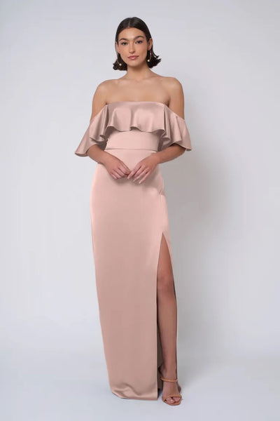 A woman in an elegant strapless neckline blush gown with a thigh-high slit, Winter by Jenny Yoo Bridesmaid Dress from Bergamot Bridal.