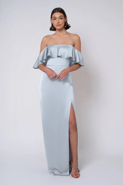 A woman in an elegant strapless light blue satin Winter - Jenny Yoo Bridesmaid Dress with a thigh-high slit from Bergamot Bridal.