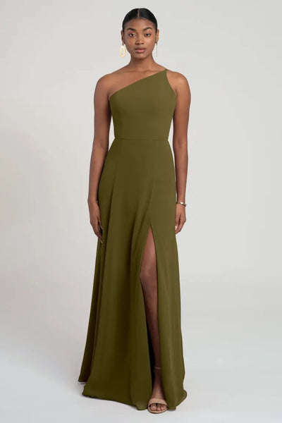 Woman in a Kora - Jenny Yoo bridesmaid dress in olive green with a thigh-high slit and a fit and flare silhouette from Bergamot Bridal.