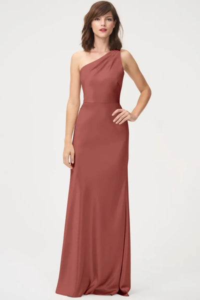 A woman in an elegant satin back crepe Lena - Bridesmaid Dress by Jenny Yoo with a one-shoulder neckline from Bergamot Bridal.