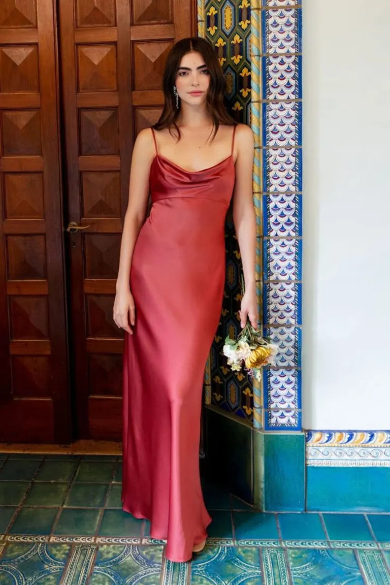 Woman in a red satin Addison bridesmaid dress by Jenny Yoo standing beside a tiled column from Bergamot Bridal.