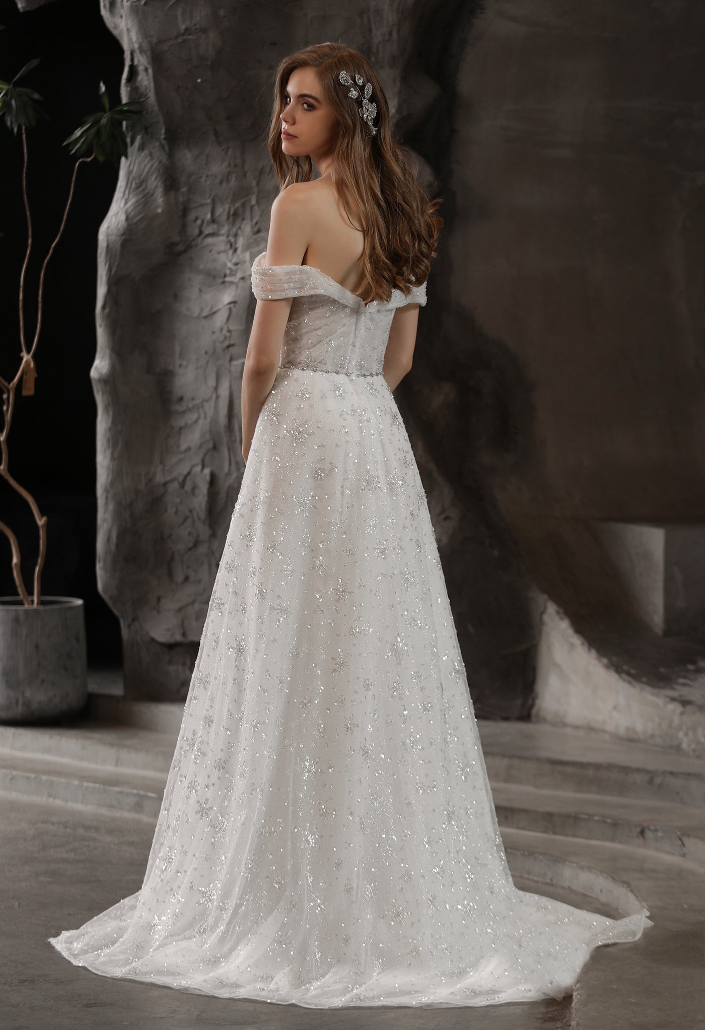 The back of a woman in a Sparkly Beaded A-Line Bridal Gown With Off the Shoulder Sweetheart Neckline at Bergamot Bridal.