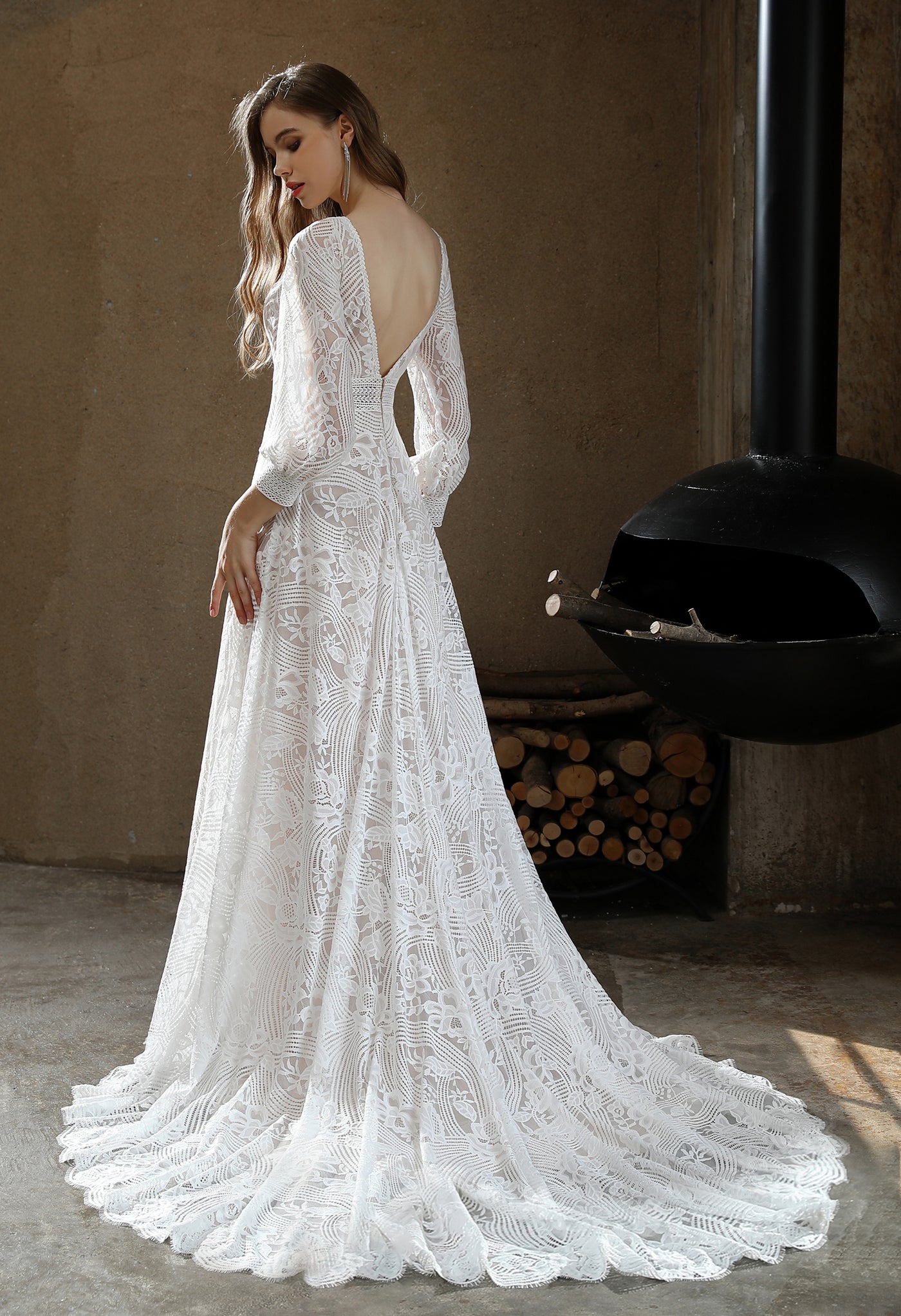 The back of a woman in a Bergamot Bridal Plunging V-neck Lace Long Sleeve Bohemian Wedding Gown.