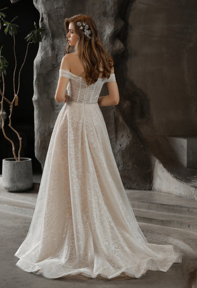 The back view of a woman in a Shimmer Off-the-shoulder Neckline A-line Tulle Wedding Dress by Bergamot Bridal in London.