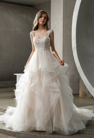 A beautiful Beaded Ruffled Ball Gown With Cap Sleeves wedding dress with a tulle skirt can be found at bridal shops in London from Bergamot Bridal.