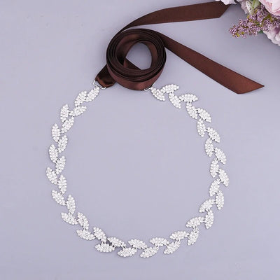 A Silver leaf crystal bridal belt sash with a brown ribbon is available at Bergamot Bridal shops.