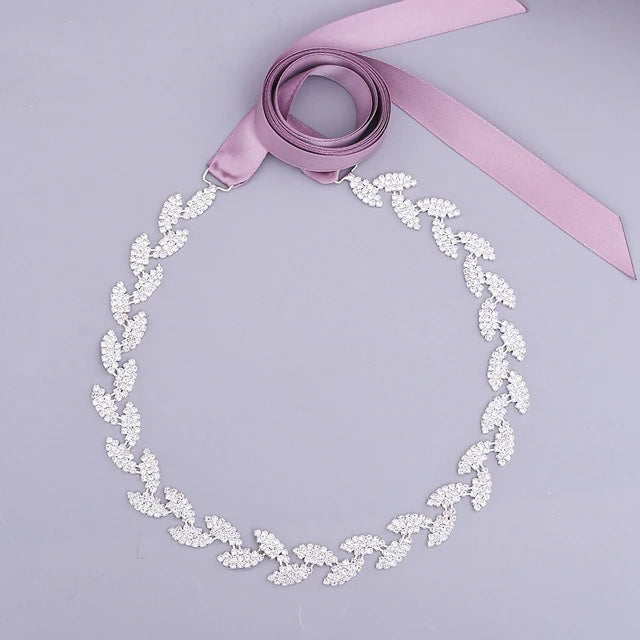 A Silver Leaf Crystal Bridal Belt Sash with a purple ribbon, available at bridal shops by Bergamot Bridal.