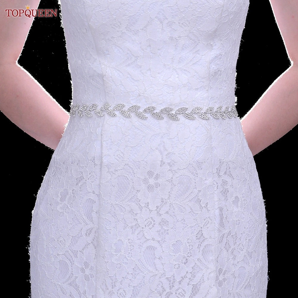 A woman wearing a white lace dress with a Silver leaf crystal bridal belt sash found at Bergamot Bridal.