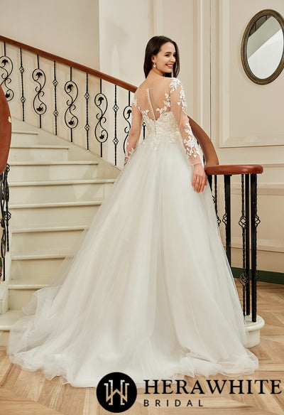 A woman in a Bergamot Bridal Vintage Inspired Lace Long Sleeve A-Line Ballgown Bridal Gown, standing on a staircase.