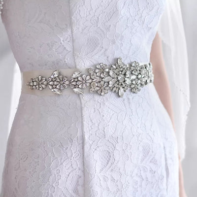 A bride in a dress with the Bergamot Bridal Sparkly Crystals Satin Bridal Sash found at bridal shops.